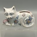 Katze, liegend, mit Blumen bemalt - Antike Keramik-Spardose, um 1900.