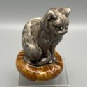 Graue Katze auf braunem Kissen. Seltene Spardose aus der Fayencerie Onnaing, Frankreich. Um 1900.