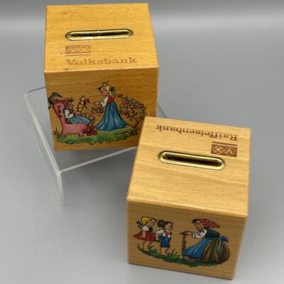 Volksbank und Raiffeisenbank. Zwei alte Holz-Spardosen mit Märchen-Motiven, 1930er Jahre